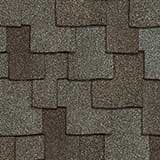 Close-up of a grey asphalt roofing texture showing overlapping rectangular shingles.