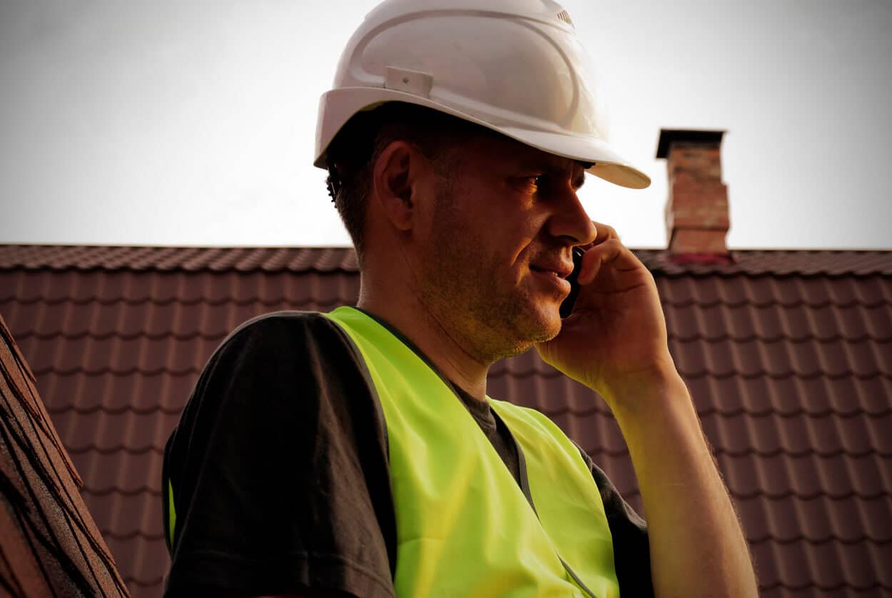 Roofer talks on phone - useful questions to ask Austin roofing contractors