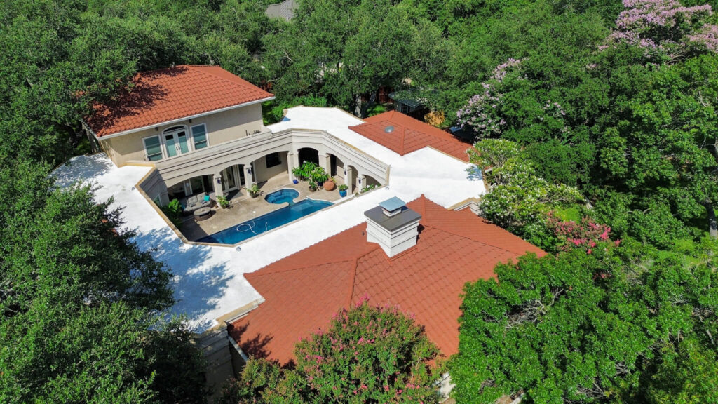 Aerial view of home with stone-coated steel roof, central courtyard, pool.