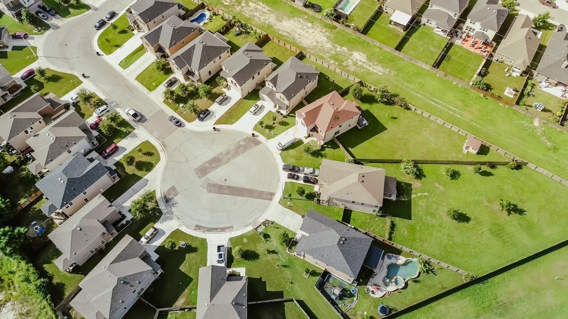 Aerial view of suburban cul-de-sac with well-maintained residential roofing systems