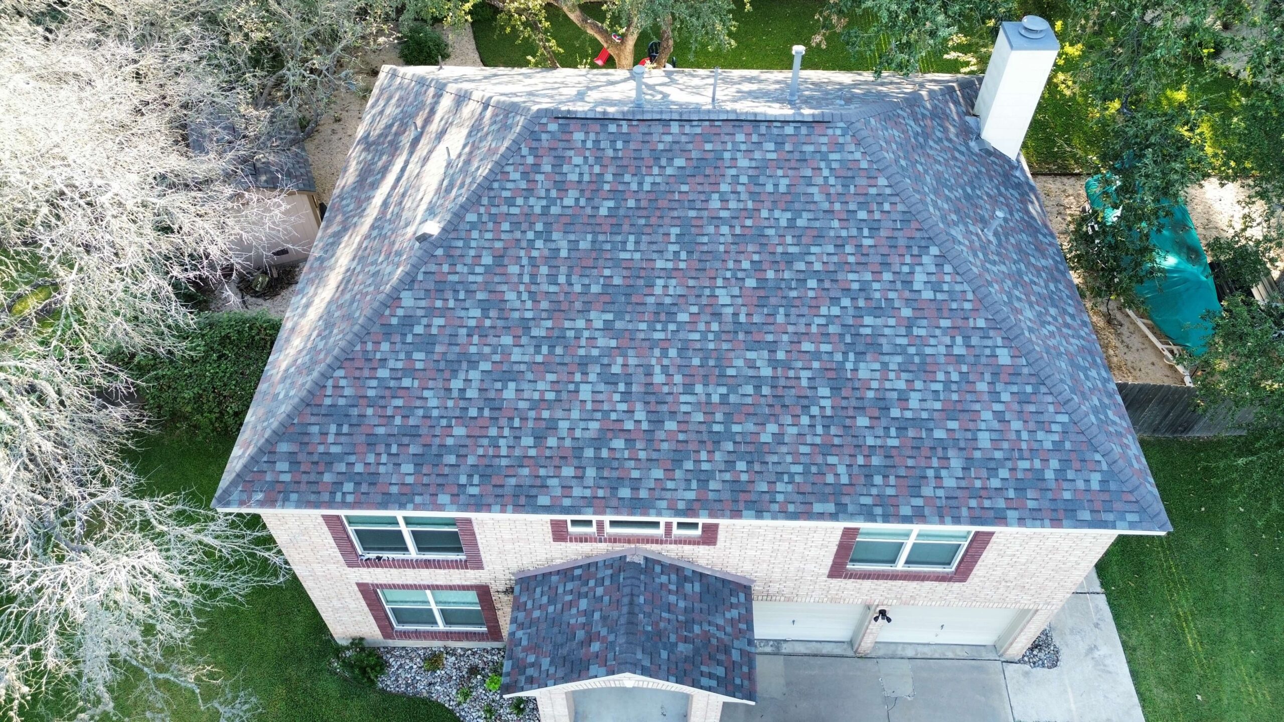 Aerial view: multi-colored shingle roof on a two-story brick house